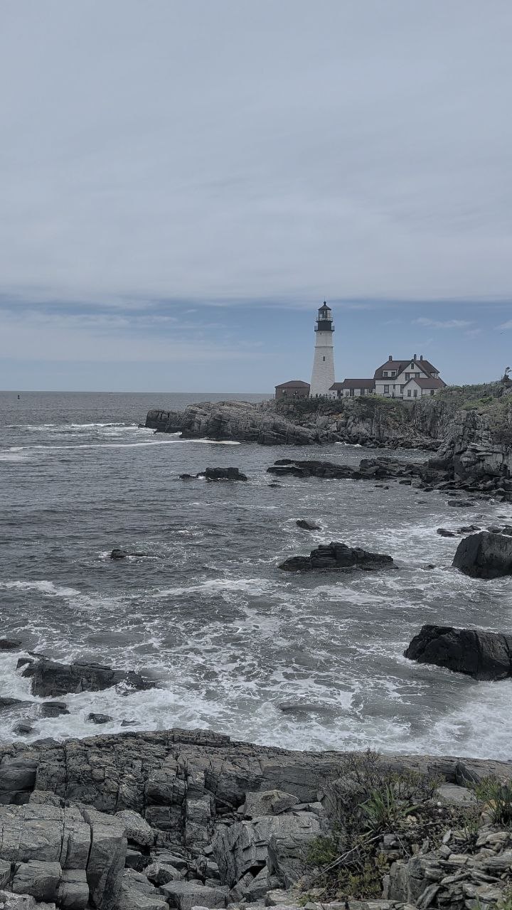 Portland Head Light — the classic view from the rocks, surf rolling in below the lighthouse and keeper's house