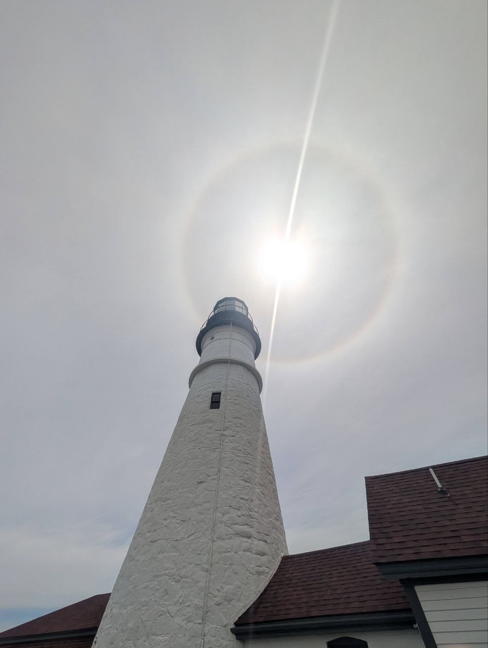 Portland Head Light from the base — looking up the tower with a sun halo ringing the lantern