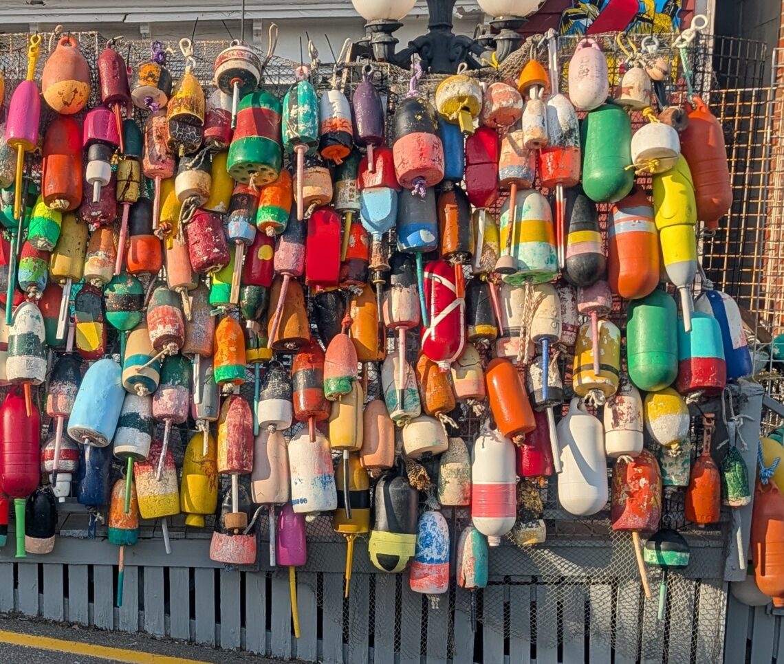 A wall of colorful Maine lobster buoys in Boothbay Harbor