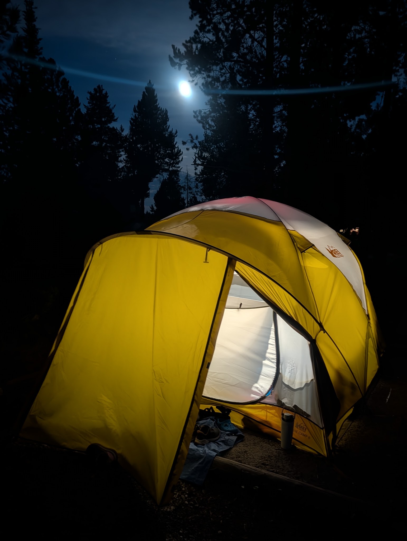 The tent lit from inside under a full moon