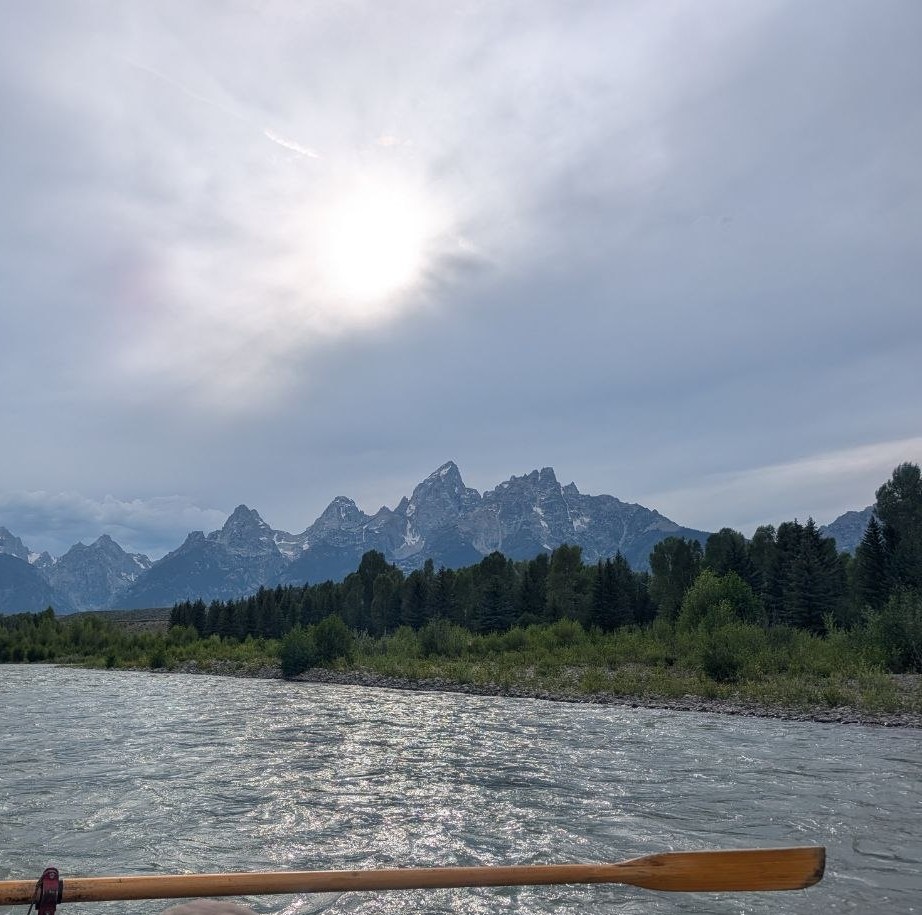 From the raft on the Snake River — the oar across the water, the Cathedral Group beyond